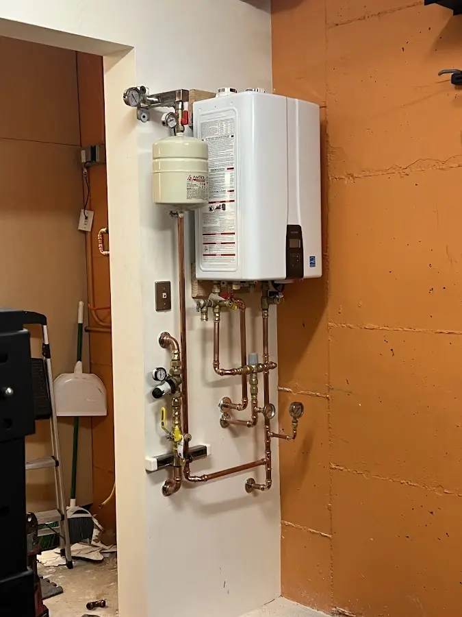 Plumbing technician inspecting water heater connections in Geneseo